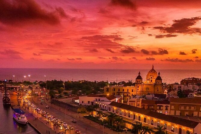 Vista aérea de Cartagena con murallas y mar Caribe al atardecer.